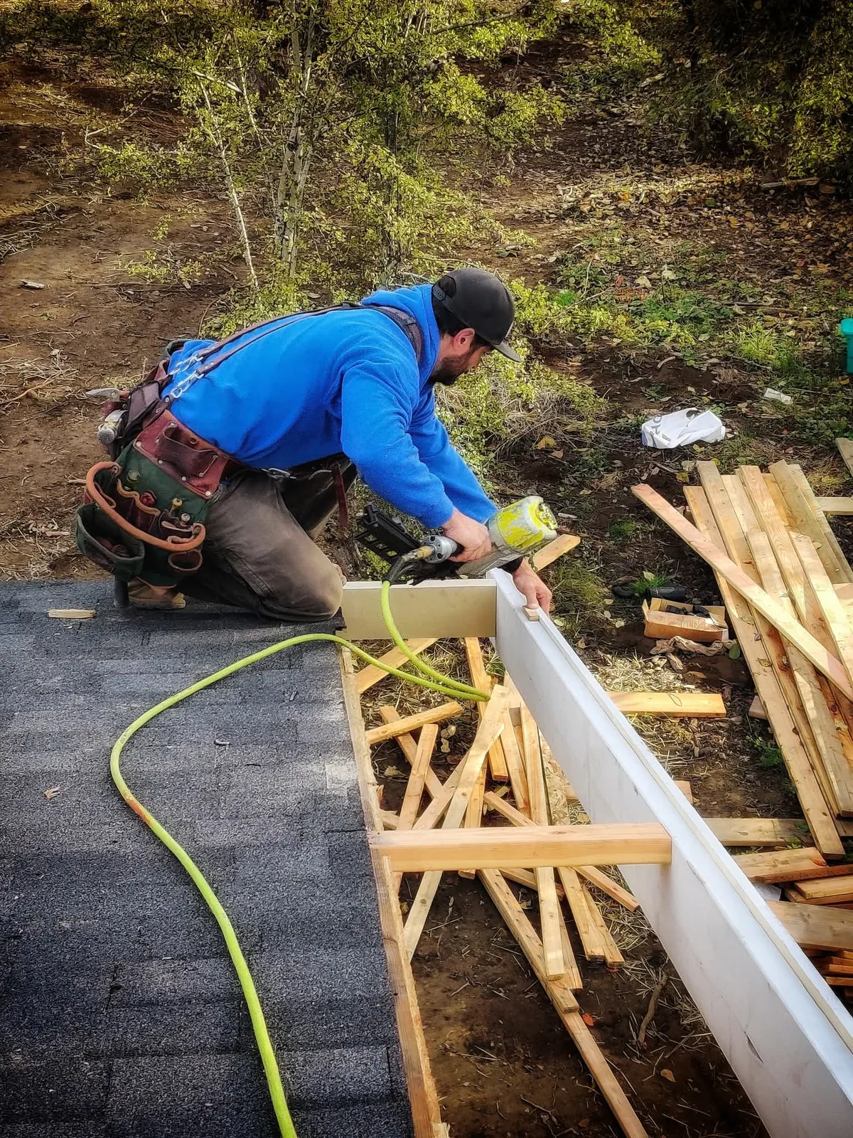 Carpenter working on exterior wall framing during residential construction