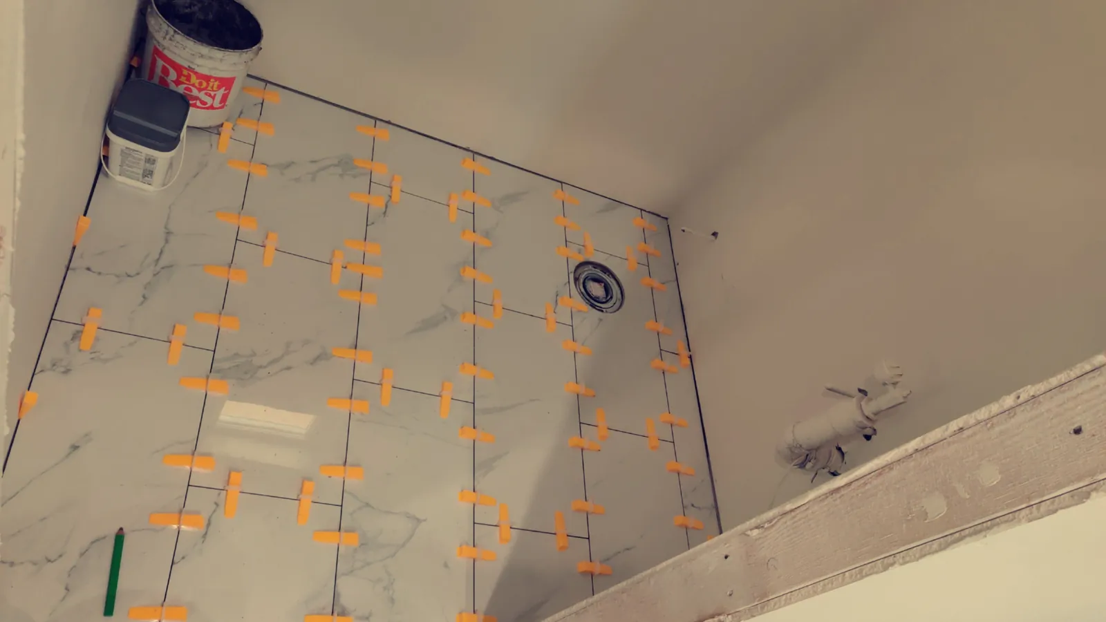 Floor tile installation over waterproof uncoupling membrane during a bathroom remodel