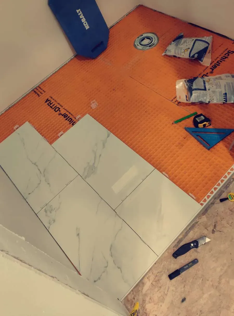 Waterproofing, drain preparation, and tile layout during an interior bathroom remodel
