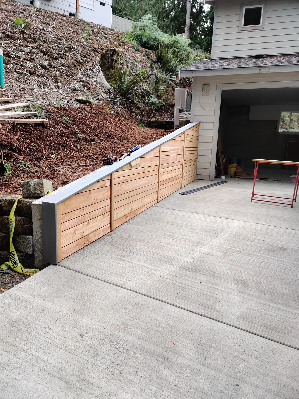Completed wood-faced retaining wall supporting grade at a residential property