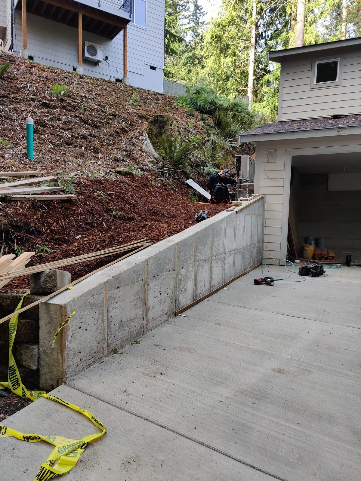 Concrete formwork and placement in progress on a residential retaining wall