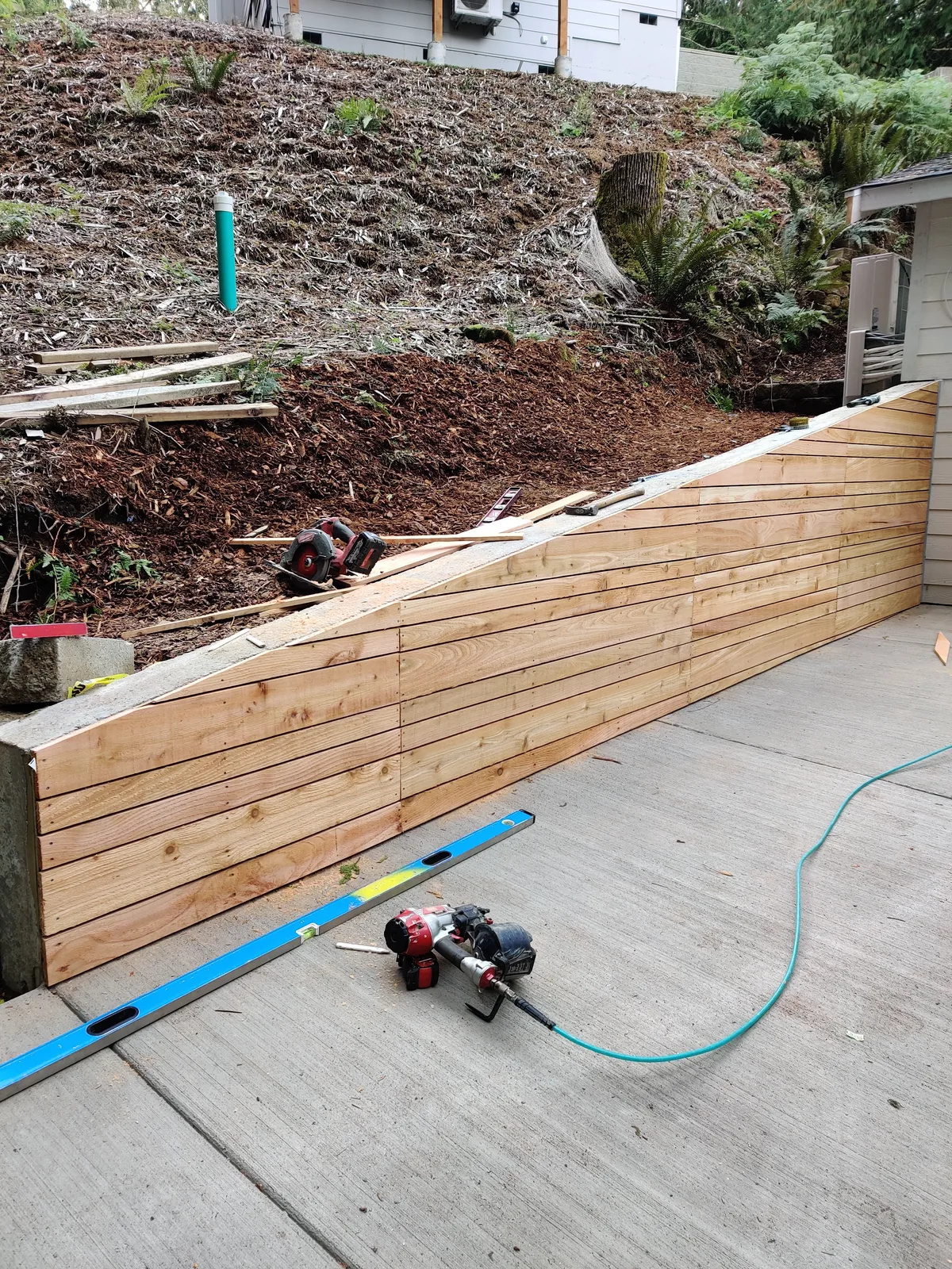 Wood-facing installation progressing on a formed residential retaining wall
