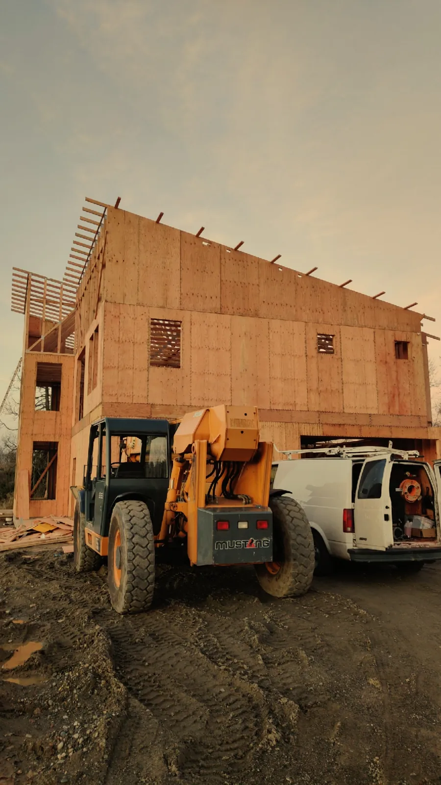 Multi-story residential home with structural framing and exterior sheathing in progress